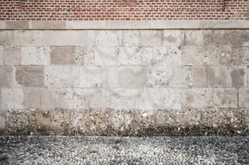 Empty grunge interior background with rough wall made of stone blocks and red bricks
