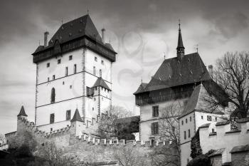 Karlstejn castle exterior. Gothic castle founded 1348 CE by Charles IV, Holy Roman Emperor-elect and King of Bohemia. Located in Karlstejn village, Czech Republic. Black and white photo