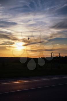 Hot air balloon flies in the evening sky, vertical photo