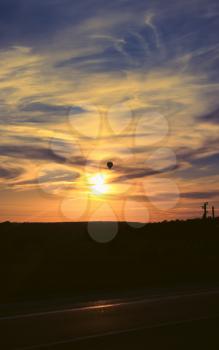 Hot air balloon flies in the evening sky, vertical background photo