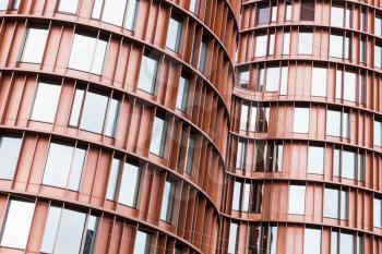 Abstract contemporary architecture background, curved walls made of red metal and glass