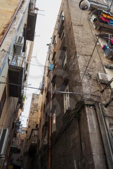Narrow street of old Naples city, living houses facades with drying clothes