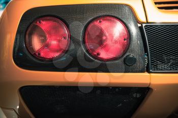 Rear lights on a luxury yellow Italian sports car, close up photo 