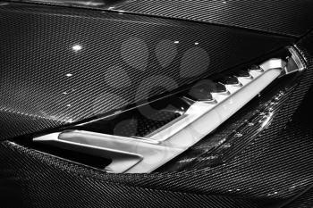 Luxury sports car fragment, headlight mounted in carbon fiber body parts