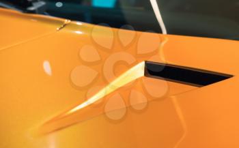 Luxury yellow roadster fragment, aerodynamics air intake system design on a car bonnet