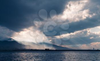 Dark stormy clouds with sunbeams, landscape background photo, bay of Izmir city, Turkey