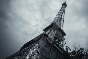 Looking up on Eiffel Tower, the most popular landmark of Paris, France. Monochrome blue toned photo
