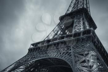 Fragment of Eiffel Tower, lower level, the most popular landmark of Paris, France. Monochrome blue toned photo