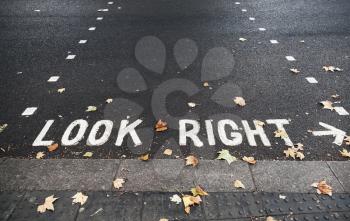 Look right. Caution road marking for pedestrians shows direction of approaching traffic in London city