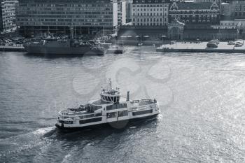 Passenger ferry enters the main port of Helsinki, Finland. Blue toned monochrome photo