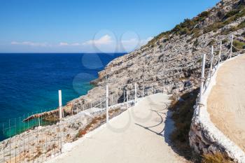 Coastal walking road with chain fences. Greek island Zakynthos in sunny summer day