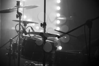 Live music photo, drum set with cymbals and stage lights on a background, black and white