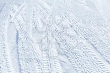 Tire tracks pattern on winter road covered with snow. Background texture