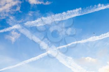 Blue sky with clouds and jet plane trails, background photo texture