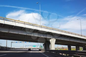 Modern speedway with overpass bridge under blue sky