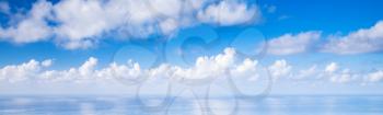 Panoramic blue sky background, white cumulus clouds over ocean