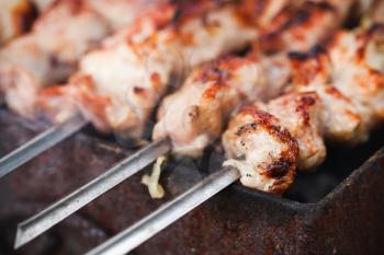 Shashlik or shashlyk, a dish of skewered and grilled cubes of meat, close-up photo