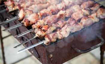 Outdoor cooking of pork Shashlik or shashlyk, a dish of skewered and grilled cubes of meat