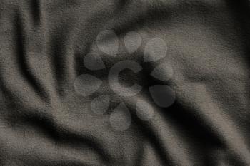 Texture of dark brown fleece, soft napped insulating fabric made from polyester, wavy pattern