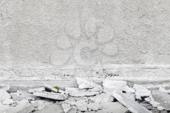Abstract gray interior background with white grungy plastering on wall and broken concrete pieces