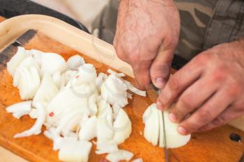 White onion chopping. Cook hands with knife, close-up photo, selective focus