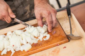 White onion manual chopping. Cook hands with knife, close-up photo, selective focus