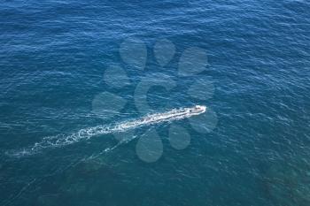 Fast motor boat goes on the ocean water, aerial photo