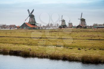 Old Windmills of Holland. Coast of Zaan river, Zaanse Schans historic town, popular tourist attraction of Netherlands