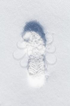 Foot imprint in fresh white snow, top view