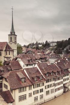 Bern old town, Switzerland. Cityscape with Nydeggkirche spire. Vintage toned vertical photo