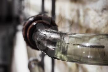 Close-up photo of glass pipeline for pumping wine at the winery, selective focus