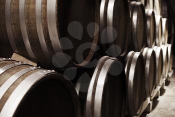 Wooden barrels in winery, close up photo with selective focus