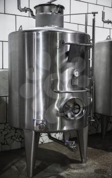 Steel barrel with manometer stands in wine factory