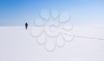 Lonely teenage girl walks along the endless snowfield, Russian winter