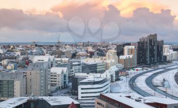 Cityscape of Reykjavik, capital city of Iceland. Modern buildings and sea under colorful cloudy sky, aerial view