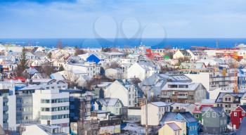 Coastal cityscape of Reykjavik, capital city of Iceland. Modern buildings and sea under cloudy sky
