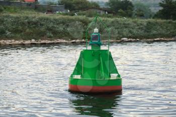 Green navigation buoy floating on sea water near coast. Varna, Bulgaria
