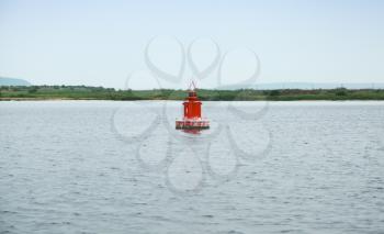 Red navigation buoy floating on still sea water. Varna, Bulgaria