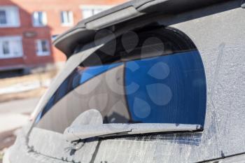 Close up photo of car wiper on dirty rear window of modern SUV car