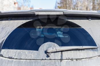 Car wiper on dirty rear window of modern SUV car