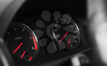 Close-up photo ob modern automotive dashboard with speedometer on black background