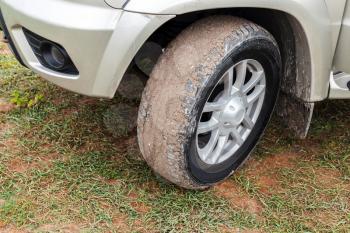 SUV car wheel with light alloy disc on dirty country ground, close-up photo