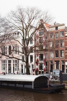 Canal street view. Winter in Amsterdam, Netherlands. Vertical photo
