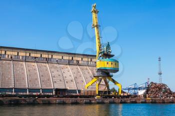 Yellow port crane near cargo terminal in Burgas port. Summer day. Seaside view