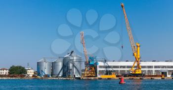 Storage tanks and port cranes. Burgas cargo port, coastal landscape in summer day