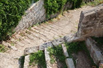 Old grungy stone stairs with grass, architecture of Corsica island, France