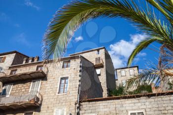 Traditional old Corsican town view with palm tree leaves. Sartene, South Corsica island, France