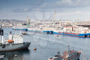 Ships moored near shipyard in Sevastopol Bay, seaside cityscape in spring day