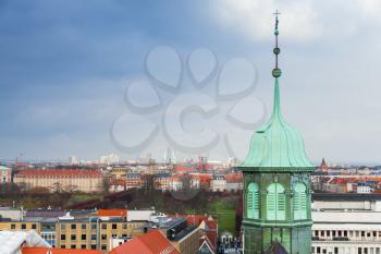 Cityscape of Copenhagen with spire of Trinitatis Church. Photo taken from The Round Tower, popular old city landmark and viewpoint. Denmark
