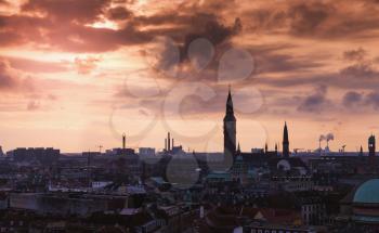 Dark silhouette skyline of Copenhagen, Denmark under colorful evening clouds. Photo taken from The Round Tower, popular old city landmark and viewpoint. 